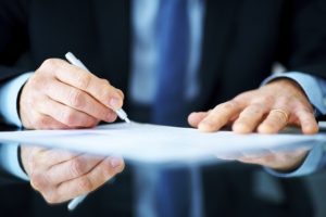 Closeup portrait of a business man hand signing on document
